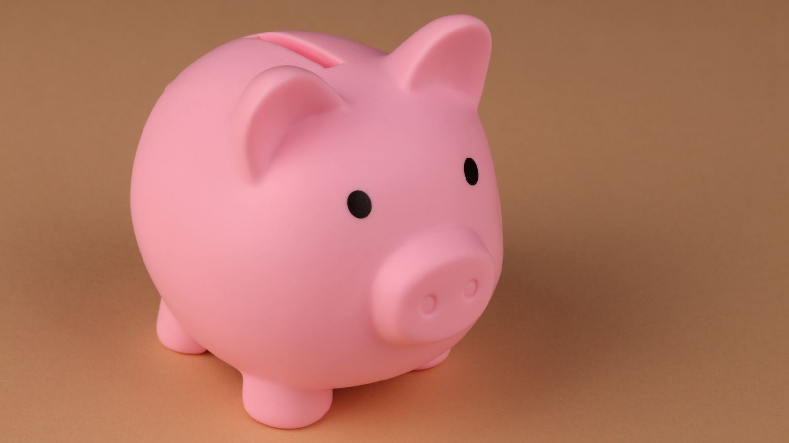Pink piggy bank on an orange-brown background